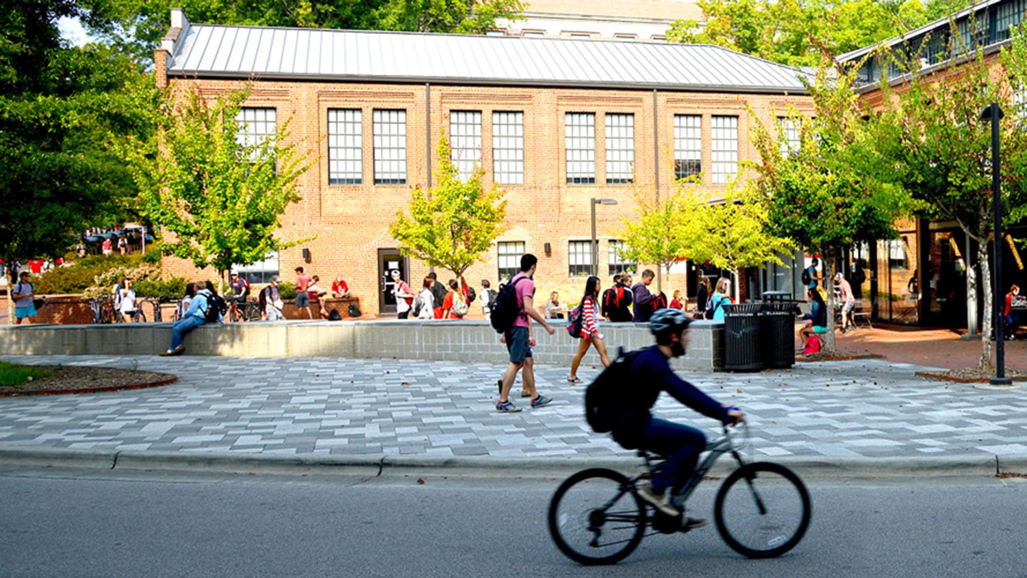 Student riding bike on NC State campus