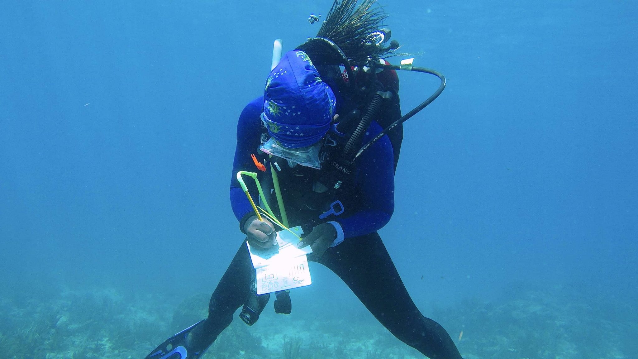 Marine science doctoral student Kayelyn Simmons makes notes while on a research dive studying underwater soundscapes off the Florida Keys.