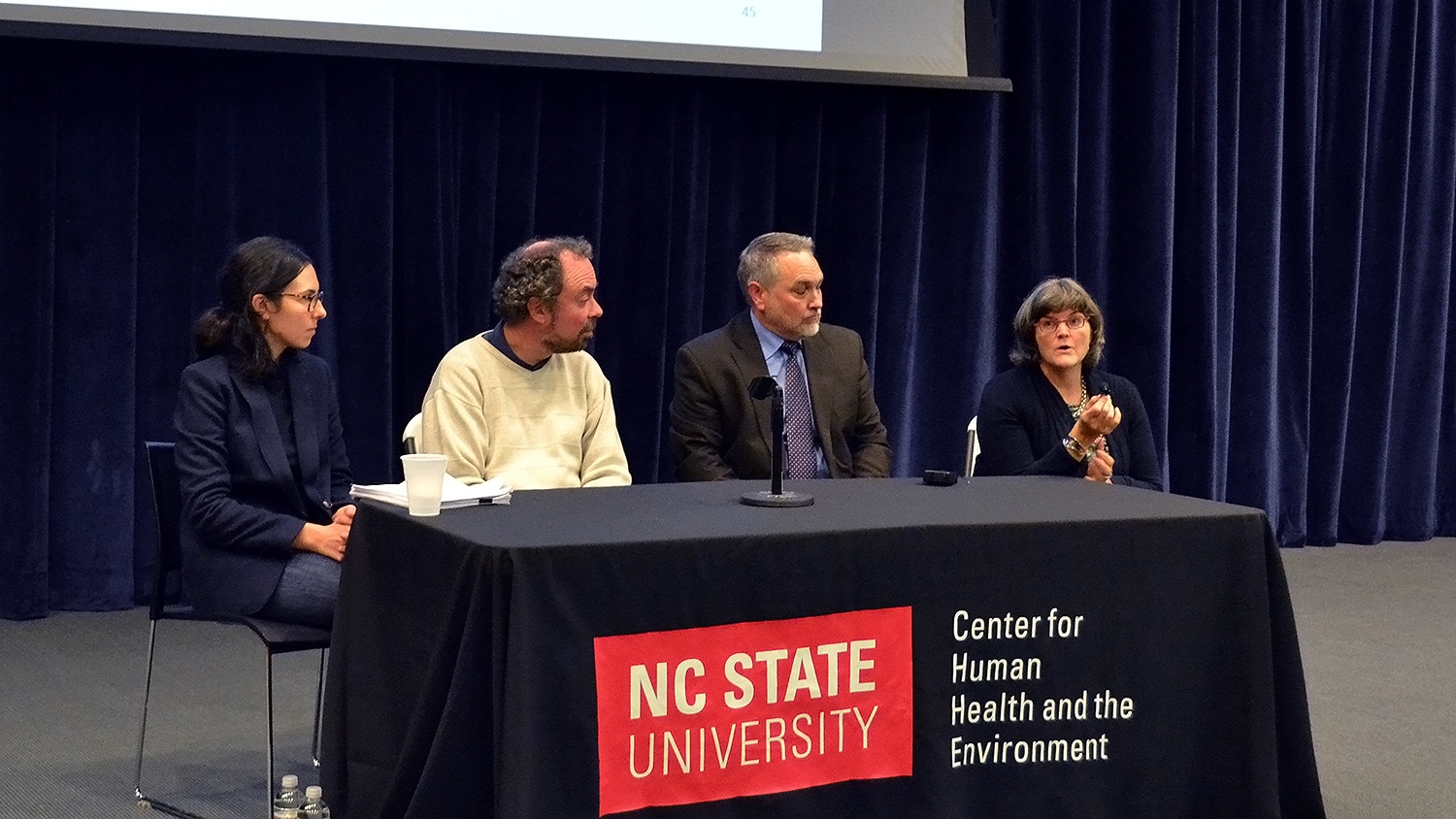 Four panelists sit behind a table with a NC State University Center for Human Health and the Environment banner