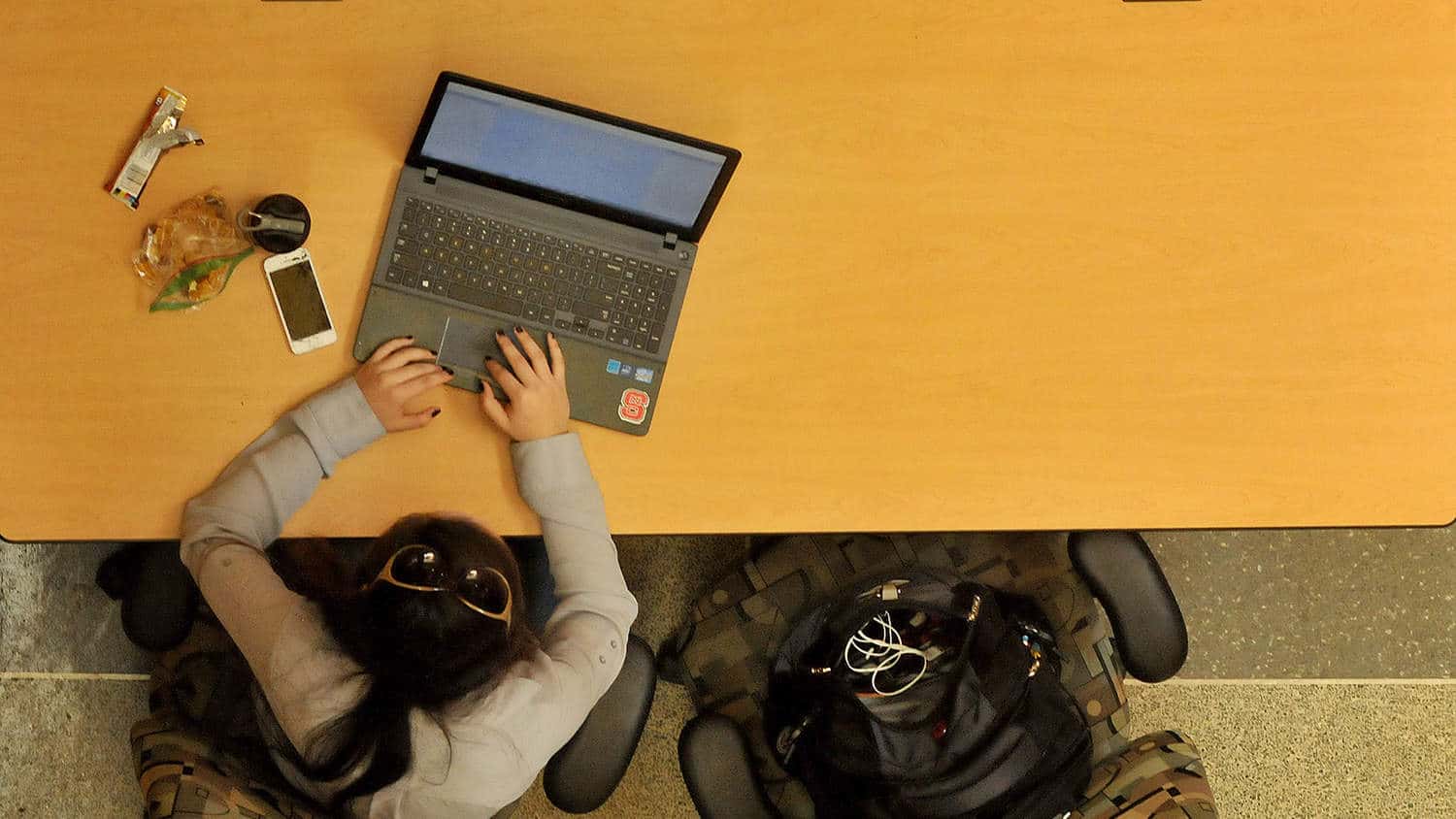 An overhead photo of a student working on a laptop at a table