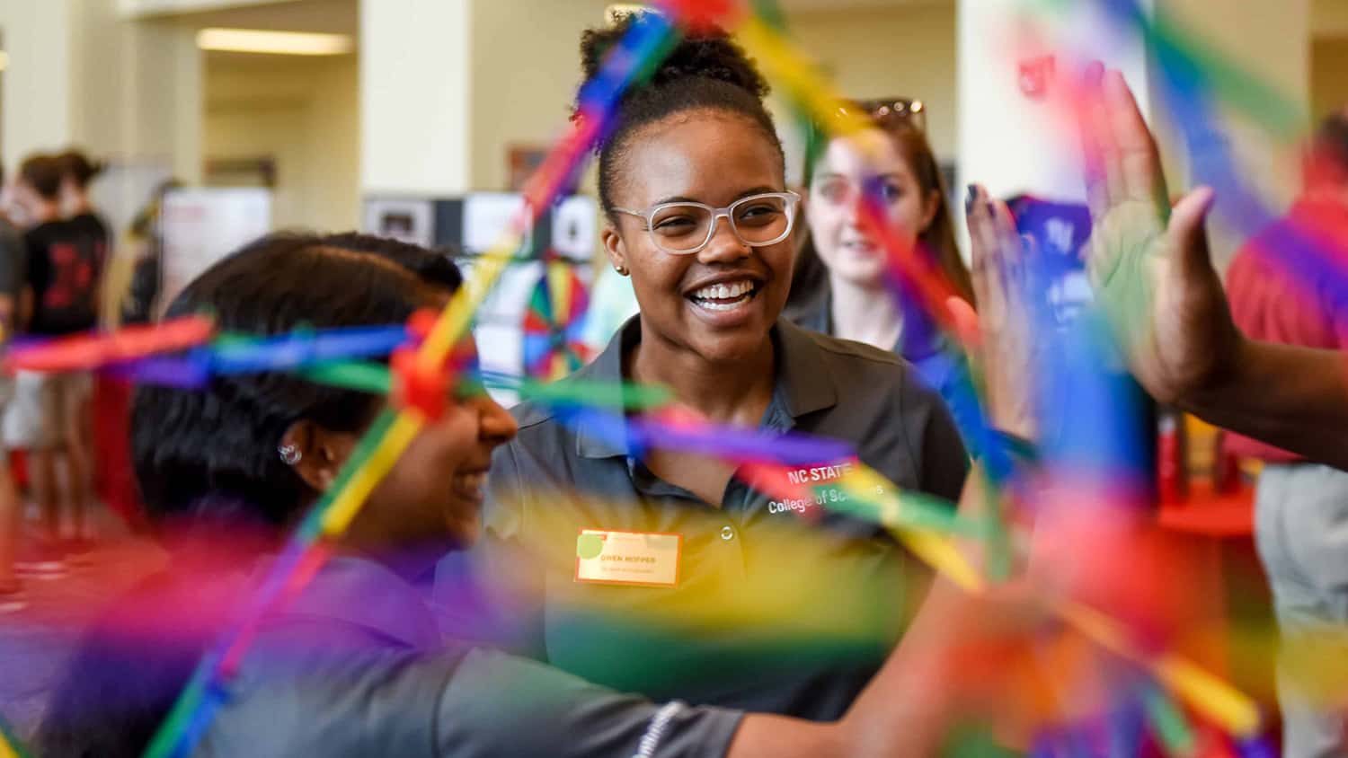 Smiling students interact with a colorful scientific demonstration at the College Connections fair