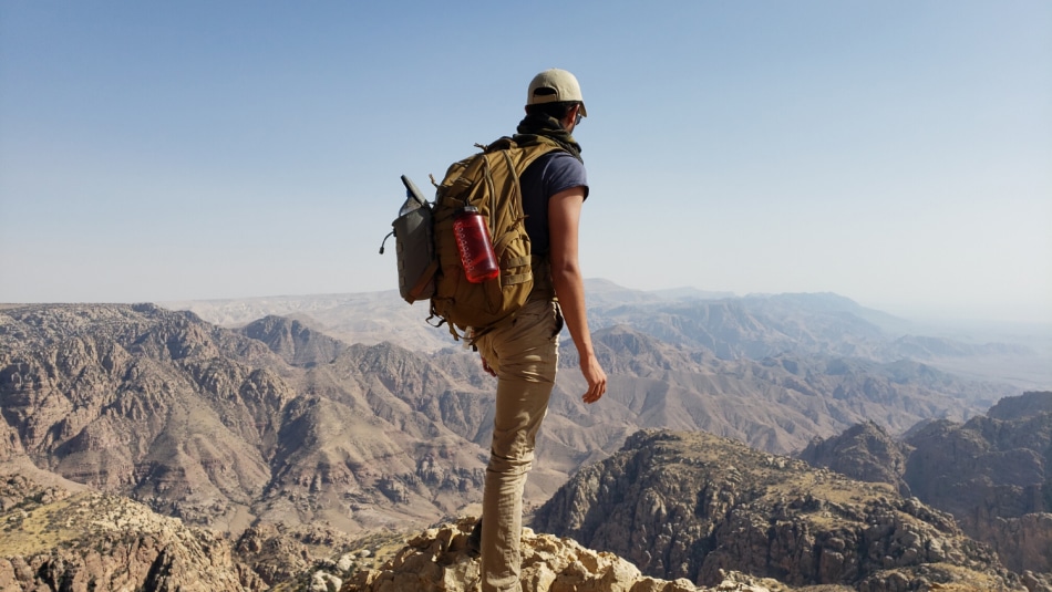 Hamil Vashi stands atop a mountain in Jordan