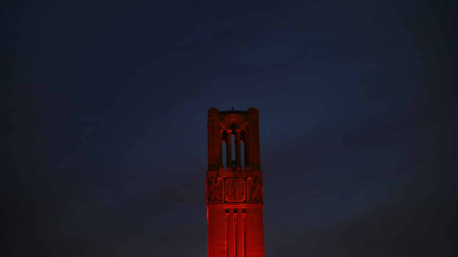 Belltower lit red against a night sky