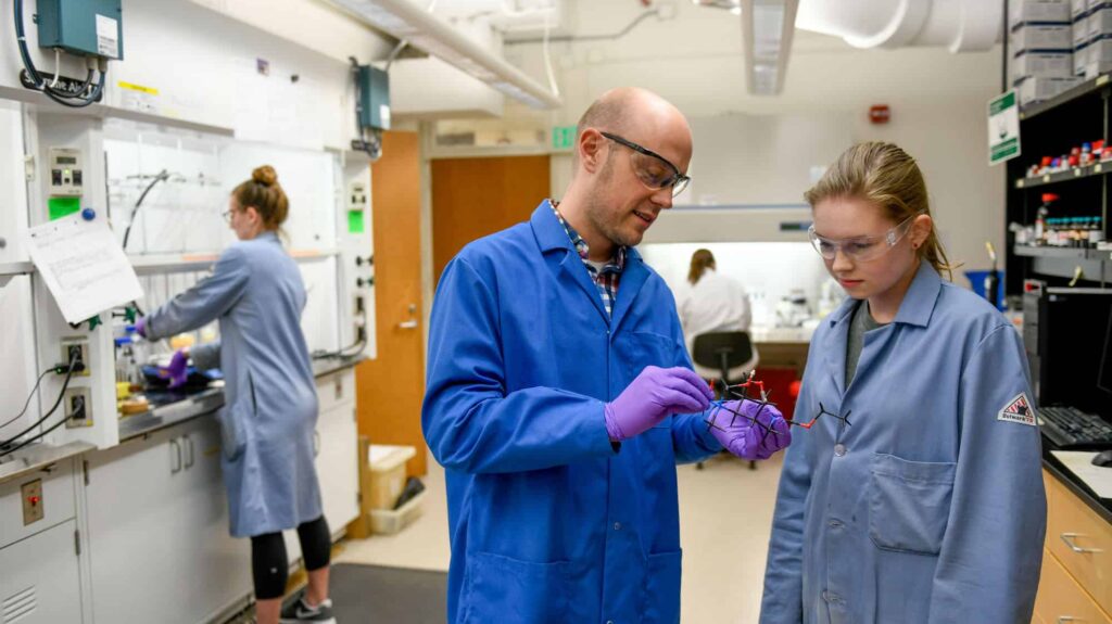 Joshua Pierce works with students in his lab.