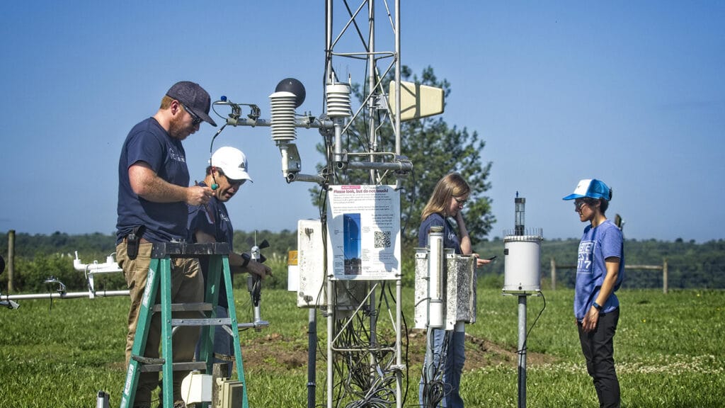 State Climate Office staff work on and around a weather station off Lake Wheeler Road