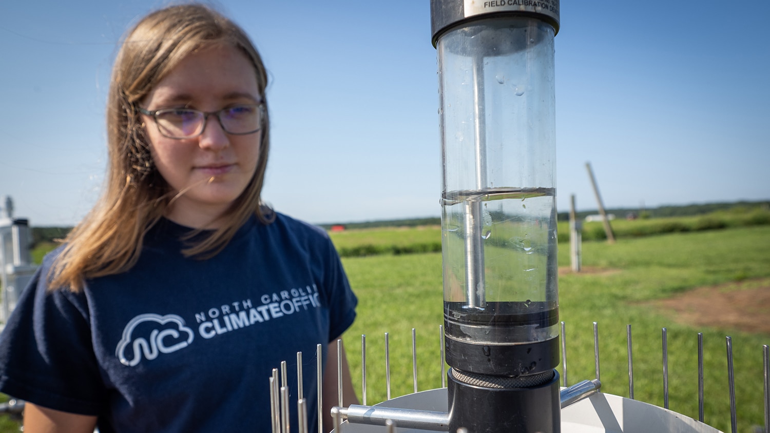SCO research technician Myleigh Neill works to recalibrate a rain gauge at a weather tower/weather station off Lake Wheeler Road.