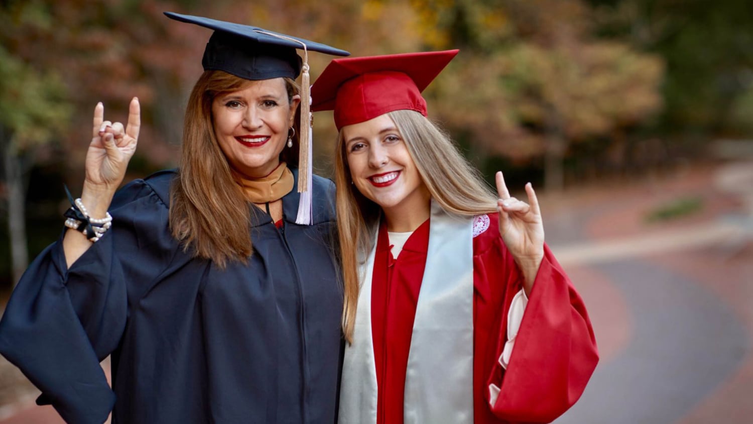 A mother and daughter in graduation caps and gowns