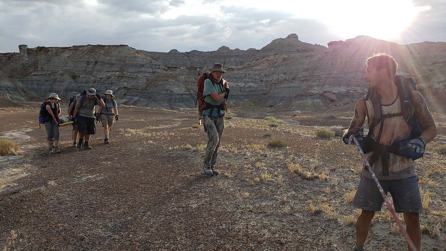 A team of paleontologist carry dinosaur bones back to their base camp.