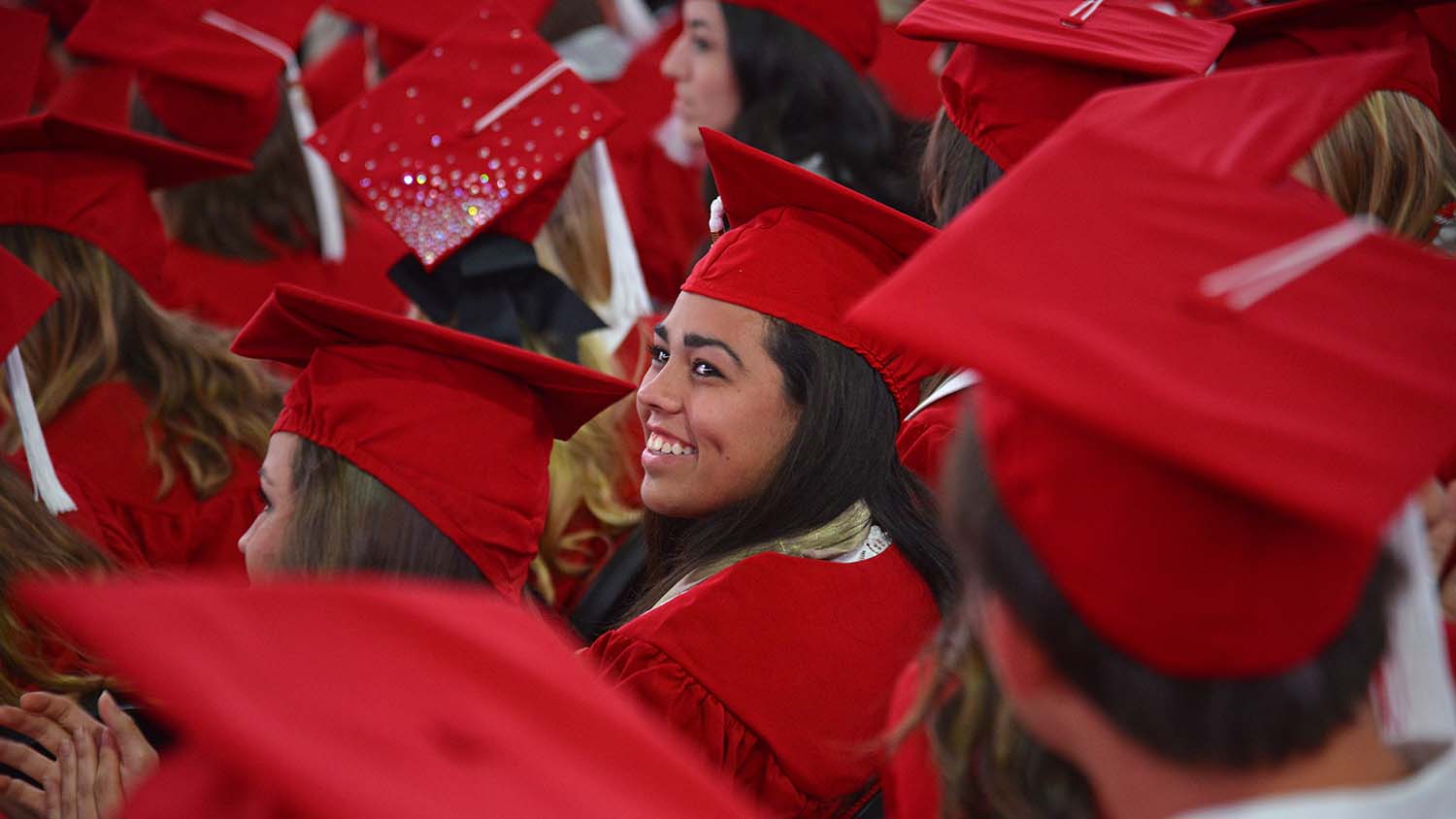 Students in red caps and gown at NC State's commencement ceremony.