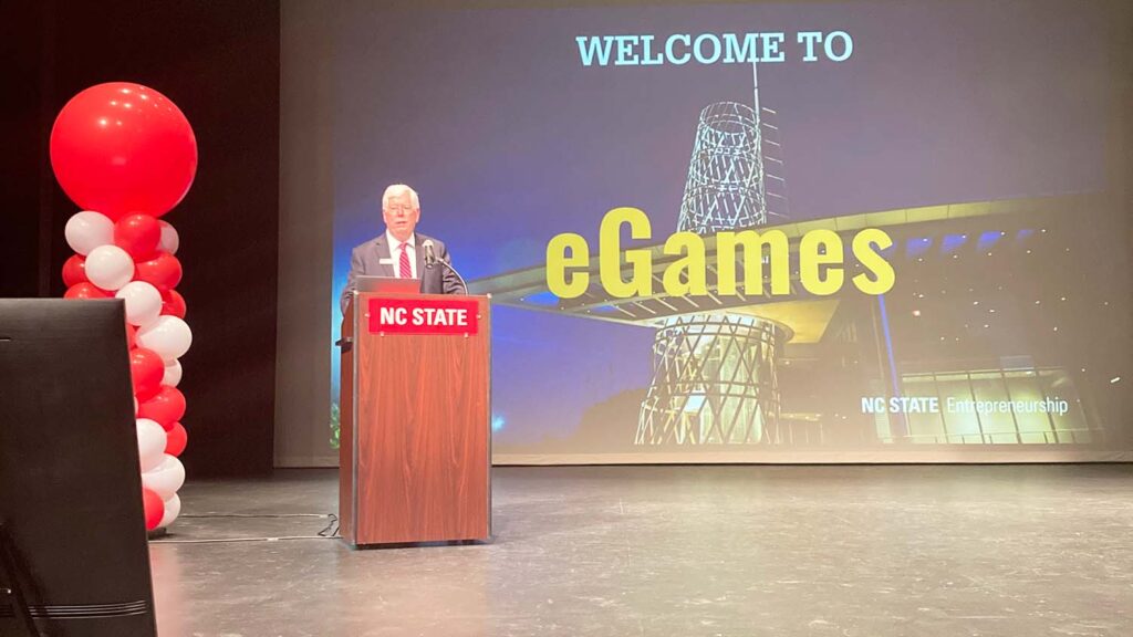A man speaking on a podium at the 2022 eGames competition.