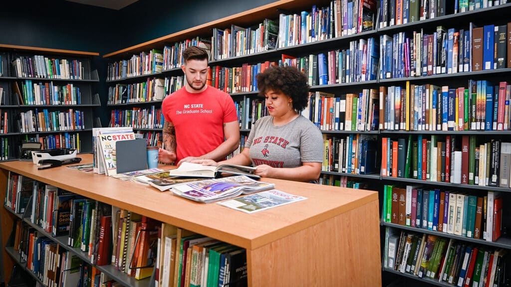 Two students look at books in the Natural Resources Library