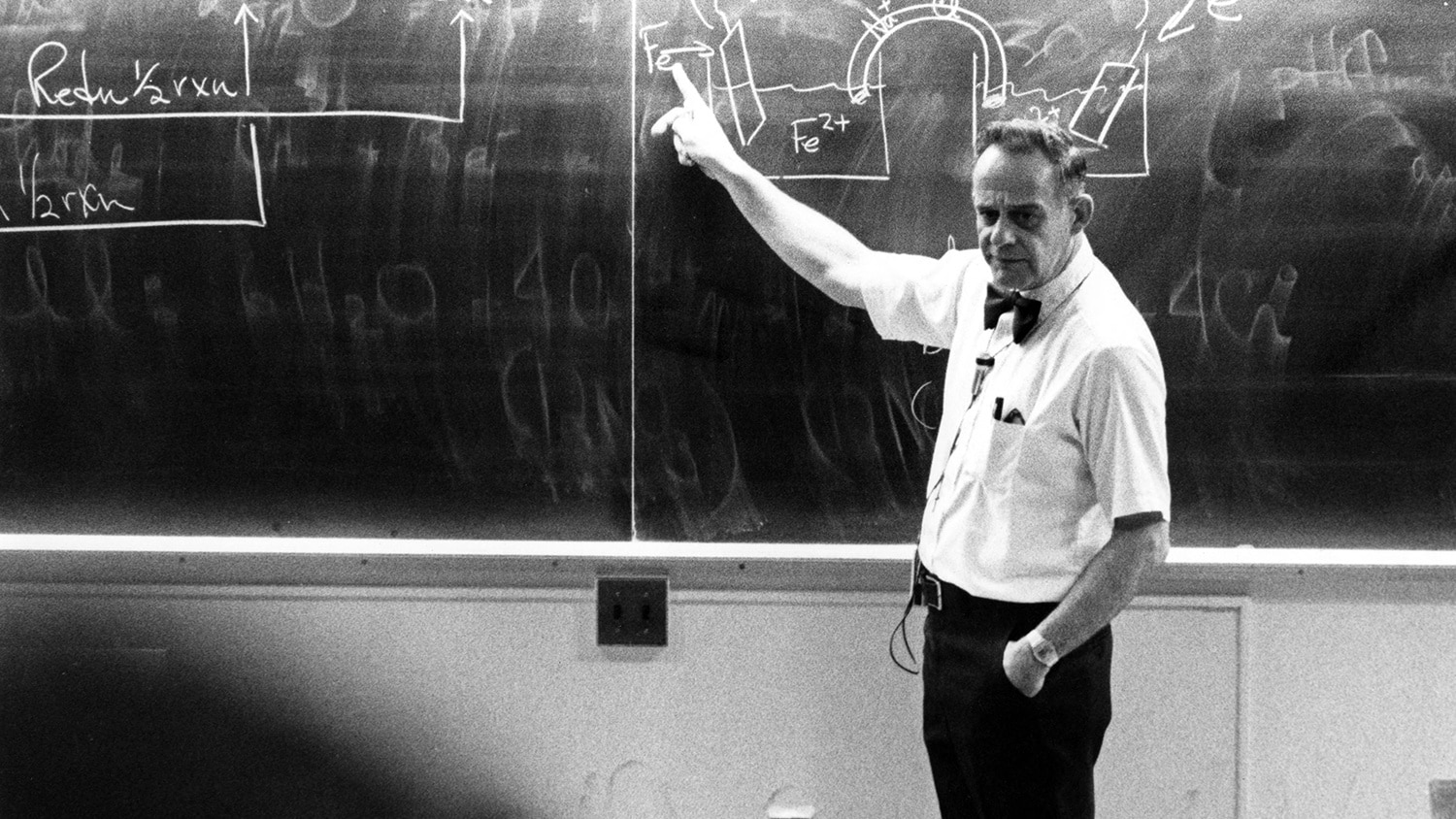 Forrest Hentz at the blackboard in an archival, black-and-white photo.