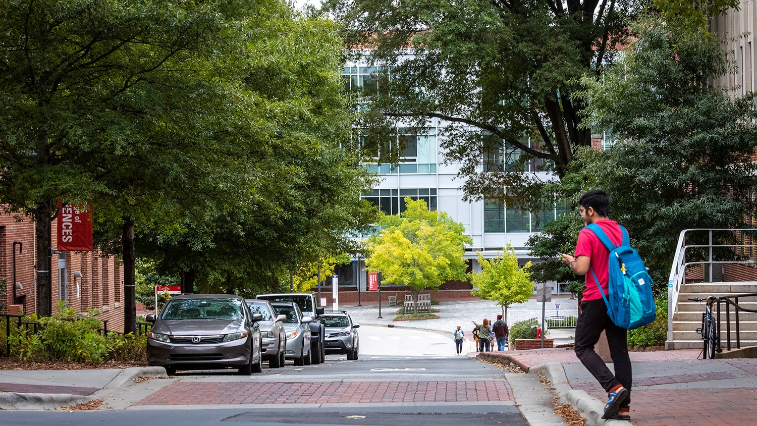 A student walks in front of SAS Hall.