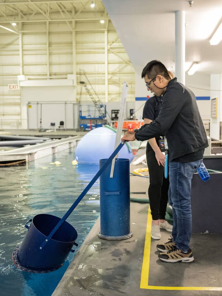 A Catalyst student holds a tool in water at the NASA Netural Buoyancy Laboratory