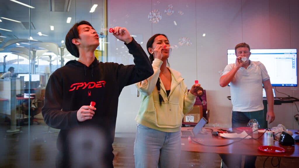 Three people blow bubbles at the 2023 State of the Sciences event