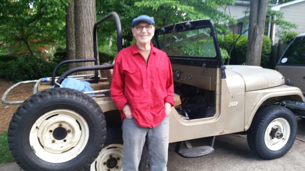 Ron Fodor stands in front of the 1960s Jeep that he was restoring
