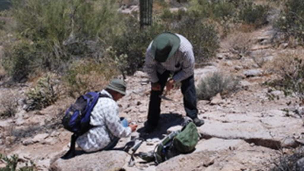 Ron Fodor and Mike Mohr inspect an 18.8-million-year-old volcanic rock in the Superstition Mountains, outside Phoenix, AZ.