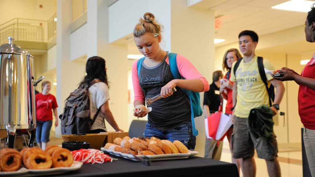 Students help themselves to doughnuts and coffee in Riddick Hall.