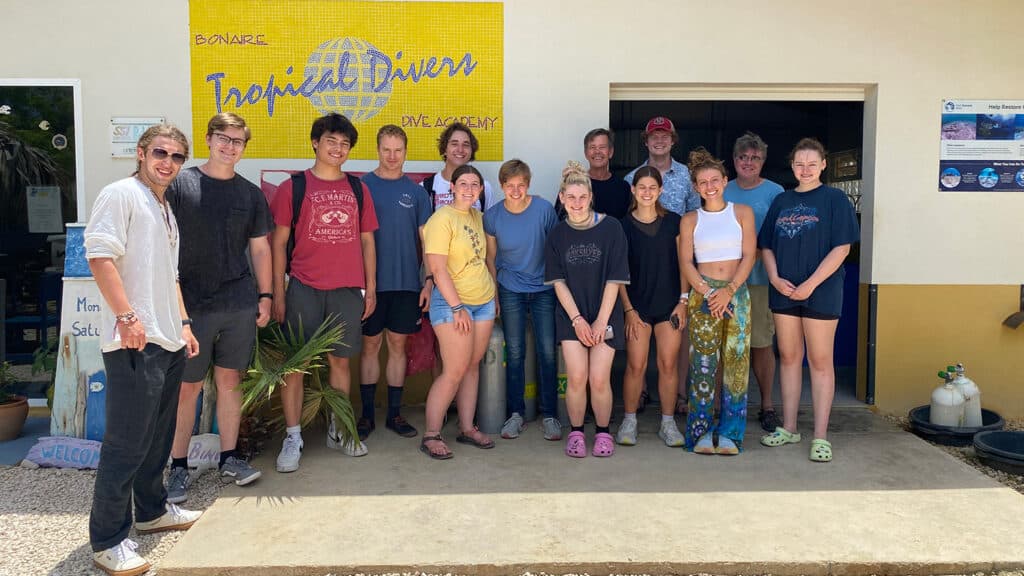 A group of students and their professors pose for a photo outside a diving resort in Bonaire