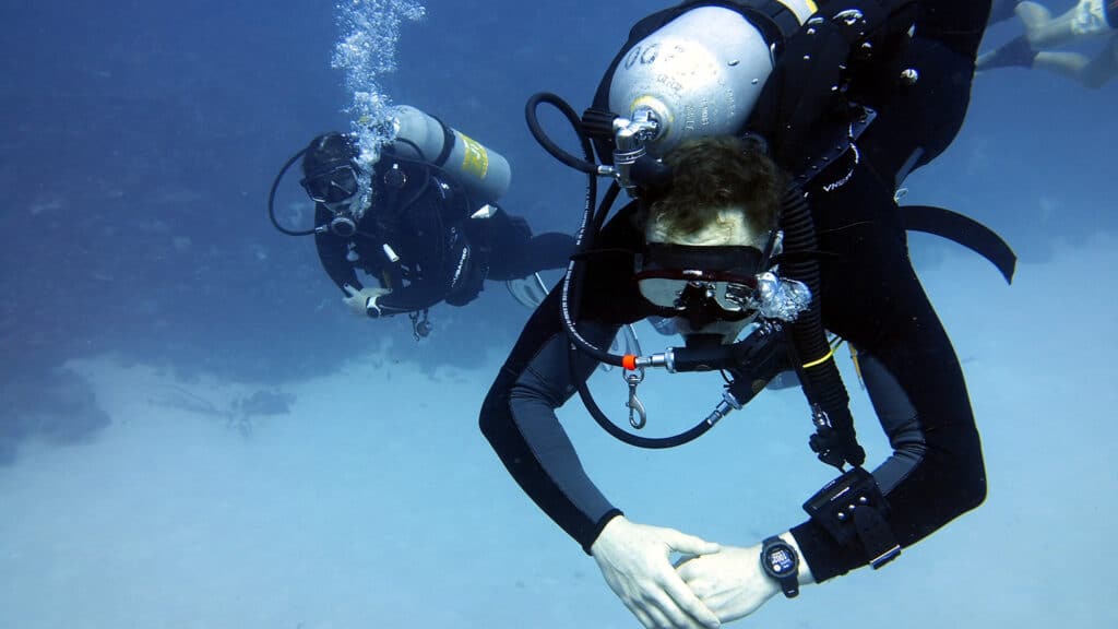 Two people scuba dive in Bonaire