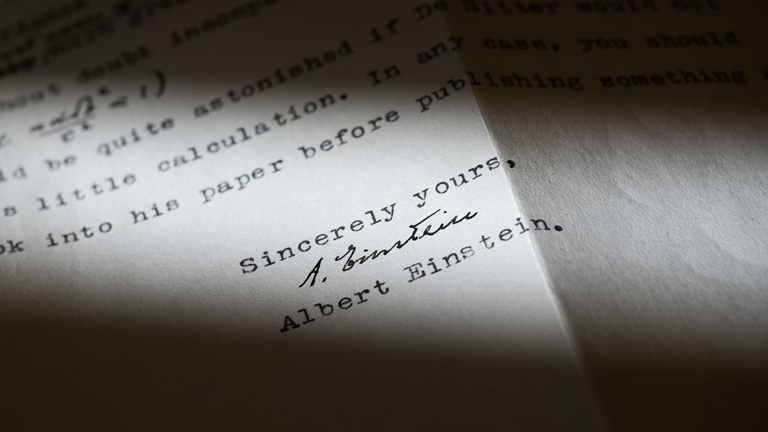 Sunlight hits a piece of paper bearing Albert Einstein's signature.