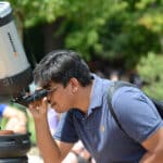 A student looks through a telescope at the viewing event in the Brickyard for the 2017 solar eclipse.