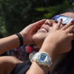 A student views the 2017 solar eclipse from the Brickyard with sun-safe glasses.