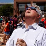 Chancellor Randy Woodson looks up at the sky wearing eclipse glasses during the 2017 solar eclipse that passed over Raleigh, N.C.