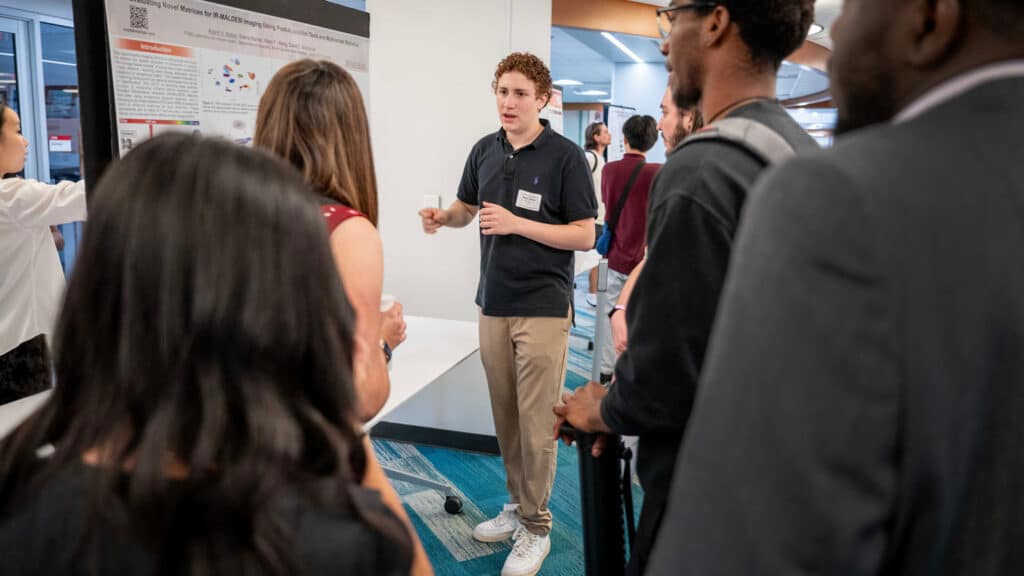 Adam Nahor speaking to a group people about his research