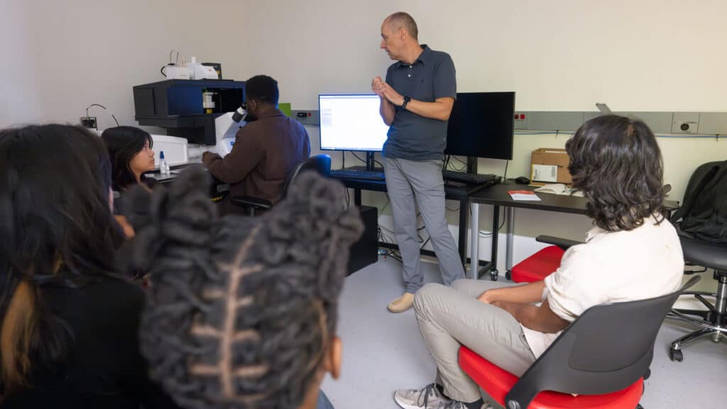 Mariusz Zareba explains to students how to use the confocal microscope