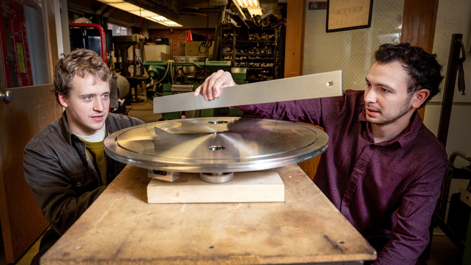 Physics graduate students Cole Teander and Clark Hickman work on a cylindrical steel structure, which they'll use to study low-energy neutrons