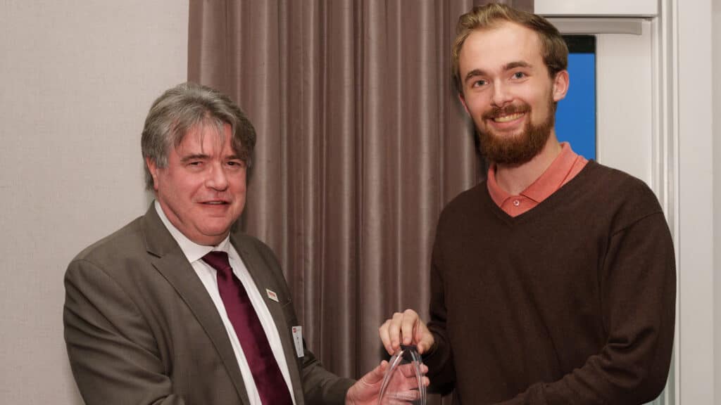 Dean Lewis Owen presents mathematics student David Sieg with an award.