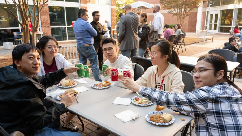 A group of students eat around a table at the Xeuss 3.0 inauguration ceremony