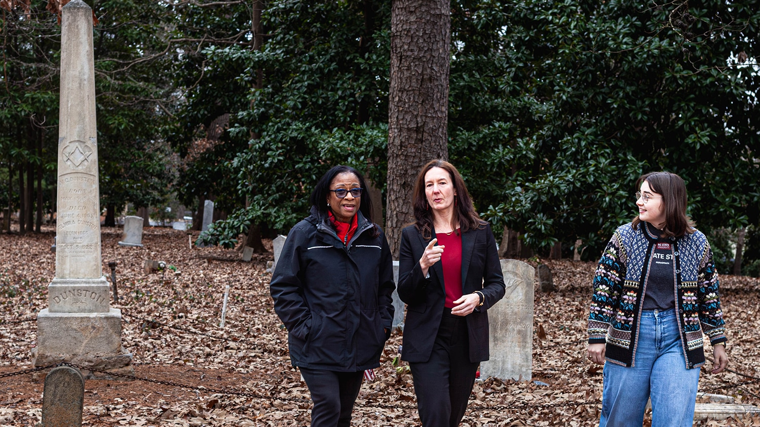 Three people walk through Oberlin Cemetery.