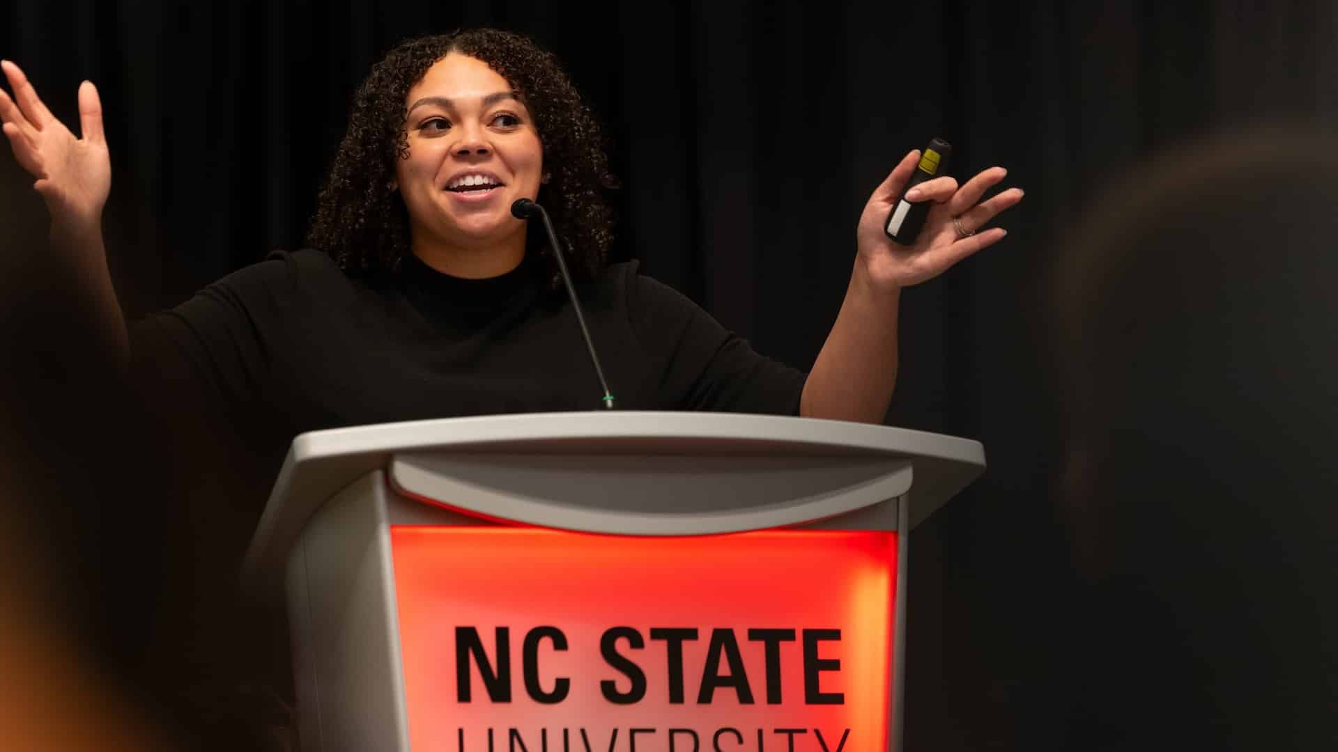 Alease Barnes speaking at a podium