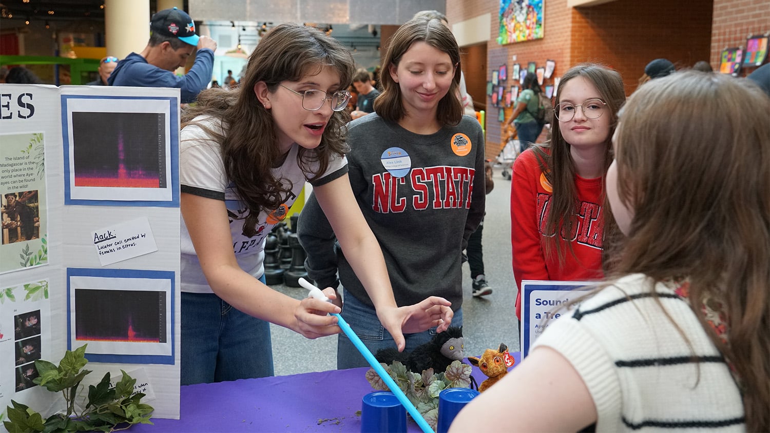 Event goers look at a project display at the Marbles Kids Museum’s first-ever Backwards Science Fair.