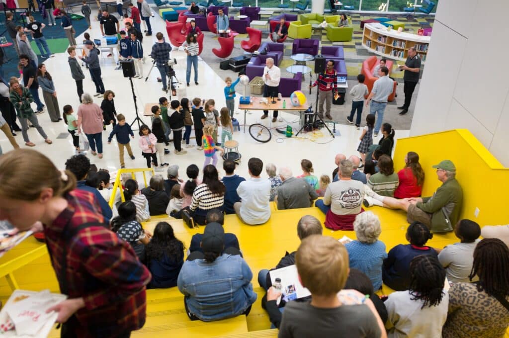 People sitting on stairs watching a presentation