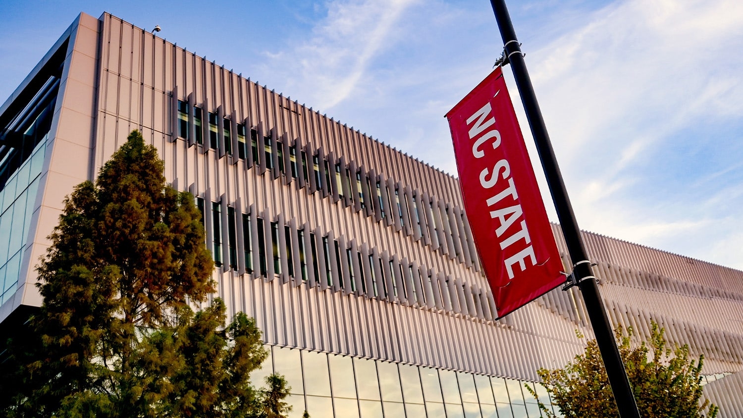 An NC State banner in front of Hunt Library on Centennial Campus