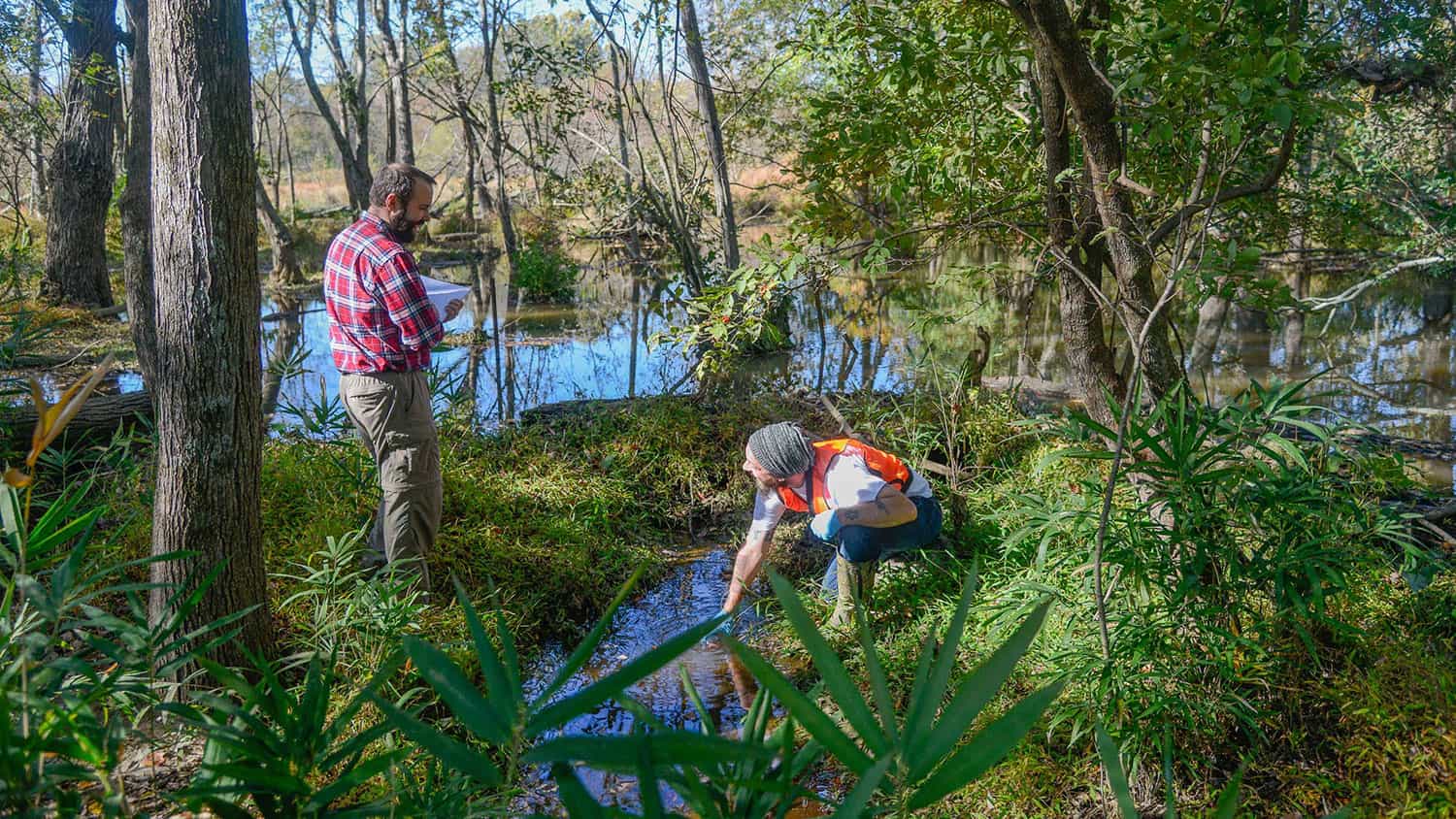 Geology students Adam Lee (left) and Dustin Travels study the effect of beavers on stream flow.