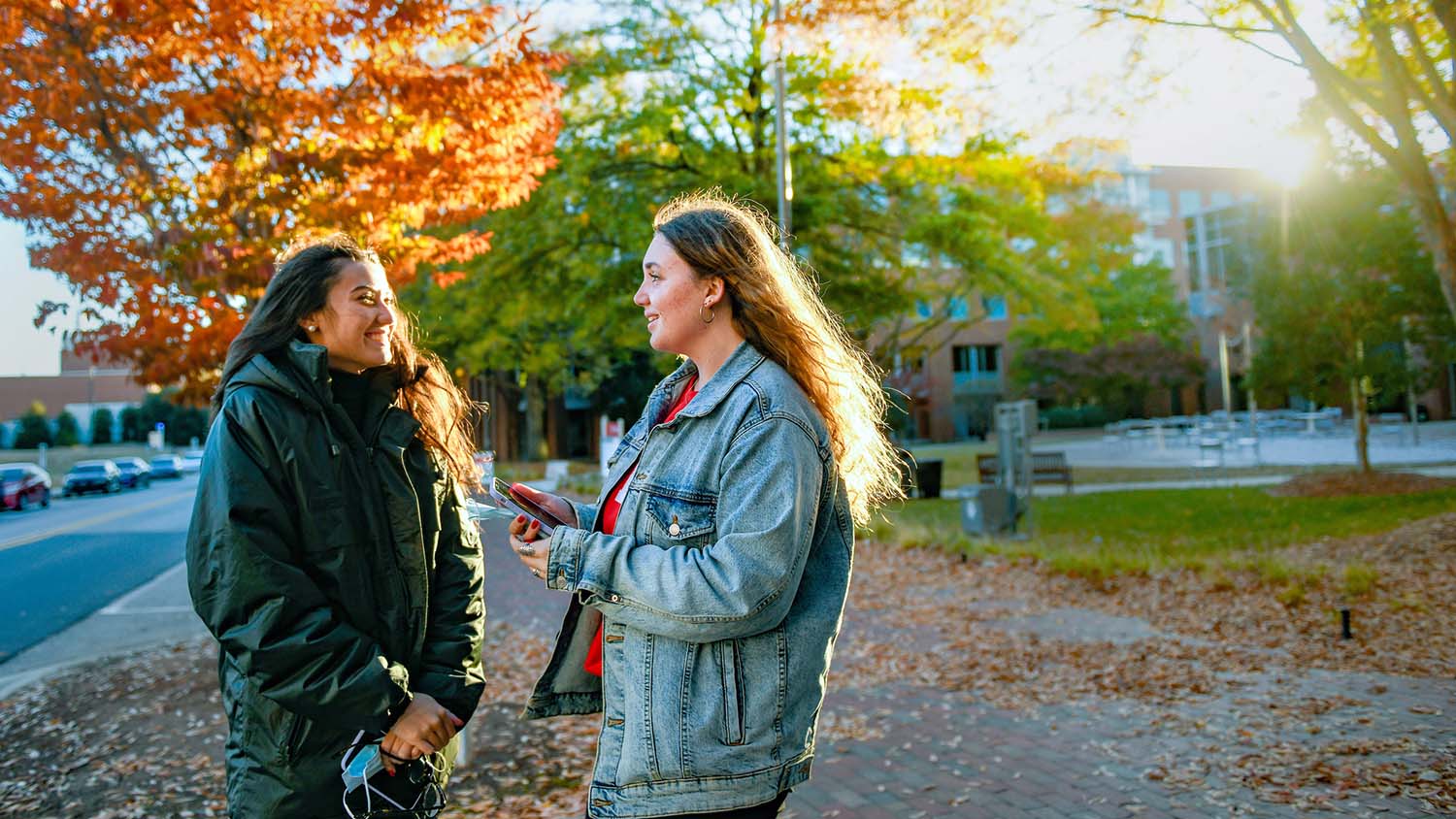 International students from France enjoy the fall weather on Centennial Campus while waiting for the Wolfline bus.