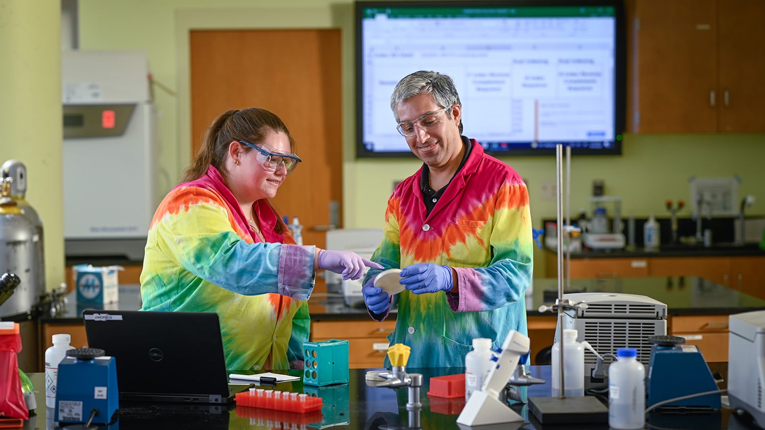 Carlos Goller, a Department of Biological Sciences faculty member who teaches in the Biotechnology Program, and a post-baccalaureate researcher, observe the growth of solid media on Comamonas testosteroni, an organism with bioremediation potential.